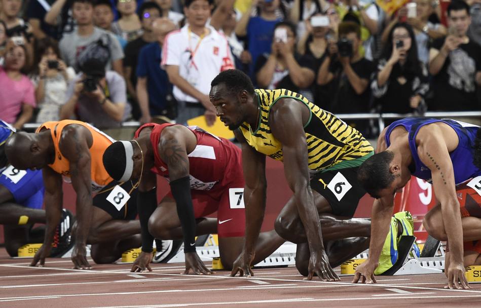 Usai Bolt ai blocchi della sua batteria dei 100 metri ai Mondiali di Pechino. Il primatista mondiale vince la sua gara con il tempo di 9
